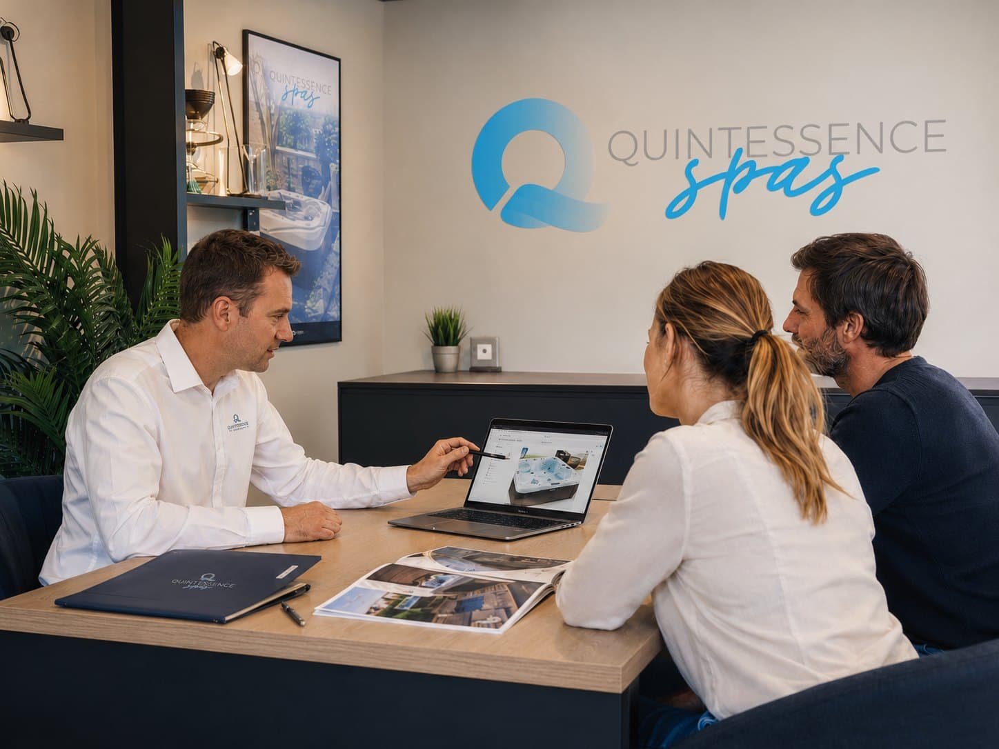 Un conseiller Quintessence Spas accompagne un couple dans le choix de leur spa, en showroom